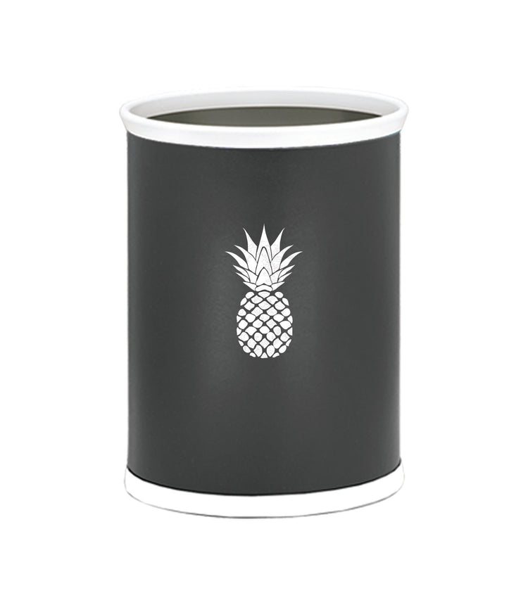 Black | Oval wastebasket featuring smooth leatherette and a white pineapple design adding a fresh touch to a coastal-themed room.