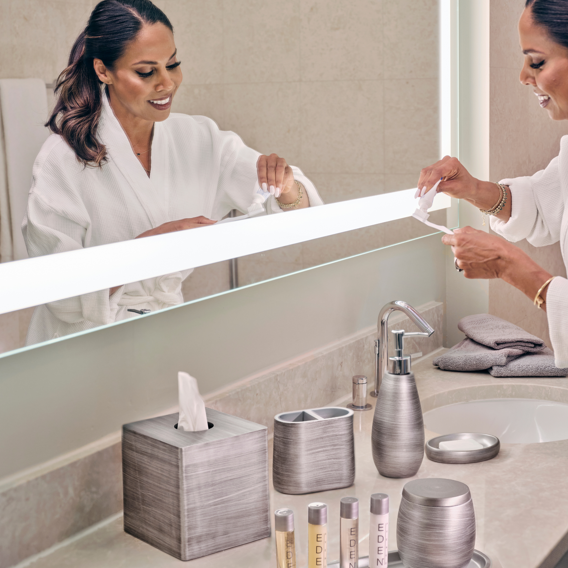 Silver | Woman in a bathrobe using a tissue in a bathroom with modern decor.